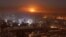 Llamas y humo iluminan el cielo sobre la asediada ciudad de Alepo, ahora controlada en su mayoría por las tropas del gobierno sirio y los milicianos.