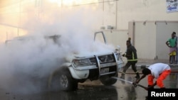 Firefighters attempt to extinguish a burning car after an explosion in Mogadishu, Somalia, Sept. 22, 2018.