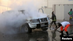 소방관들이 22일 모가디슈 중심부에서 폭발한 차량의 화재를 진압하고 있다.