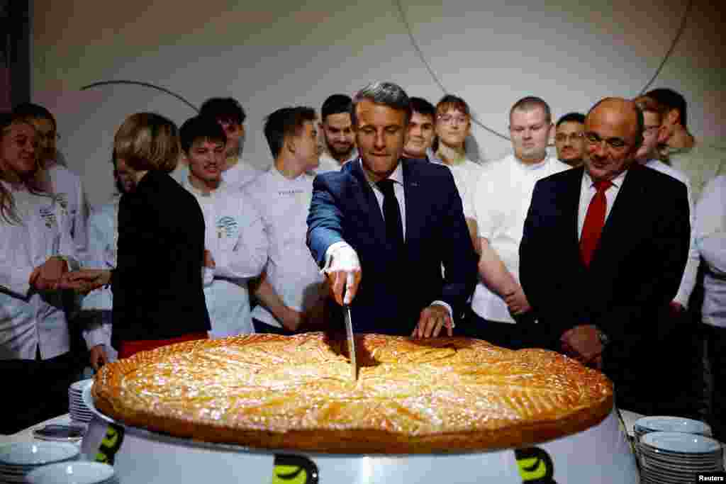 French President Emmanuel Macron cuts the Epiphany cake after a speech to the French Bakery and Pastry Federation members during the traditional Epiphany cake ceremony at the Elysee Palace in Paris.