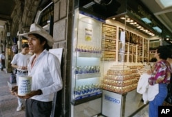 FILE - Manuel Garcia a peasant from the state of Puebla ask for money outside of a jewelry store in Mexico City's main square, Aug. 31, 1995.