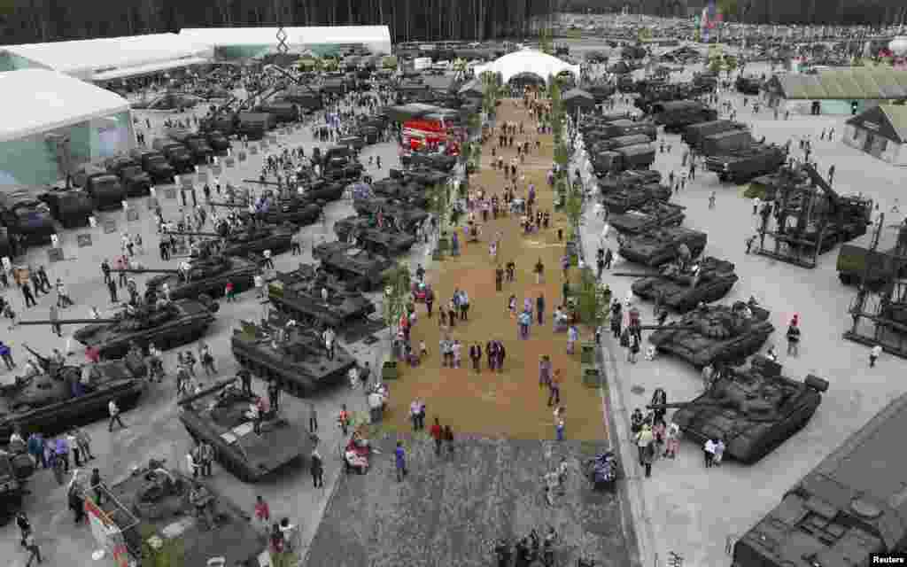 Visitors walk near exhibits that are on display at the Army-2015 international military-technical forum in Kubinka, outside Moscow, Russia.