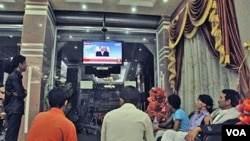 Warga di Yaman menonton siaran TV pernyataan Presiden Ali Abdullah Saleh setelah terjadinya serangan (3/6).