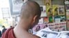 A Buddhist monk reads a journal at a roadside shop in Rangoon, Burma, Tuesday, Feb. 28, 2012. 