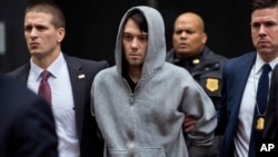 Martin Shkreli, former hedge fund manager under fire for buying a pharmaceutical company and ratcheting up the price of a life-saving drug, is escorted by law enforcement agents after being taken into custody, in New York, Dec. 17, 2015.