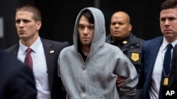 FILE - Martin Shkreli, the former hedge fund manager under fire for buying a pharmaceutical company and ratcheting up the price of a life-saving drug, is escorted by law enforcement agents after being taken into custody following a securities probe, in New York.