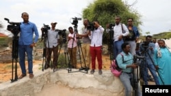 FILE - Somali journalists are seen during a stake-out on the outskirts of Mogadishu, Somalia, July 25, 2019.