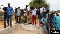 FILE - Somali journalists are seen during a stake-out on the outskirts of Mogadishu, Somalia, July 25, 2019.