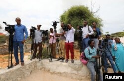 FILE - Somali journalists are seen during a stake-out on the outskirts of Mogadishu, Somalia, July 25, 2019. Conditions for Somali reporters have worsened as coverage of the coronavirus pandemic has brought new challenges and repression.