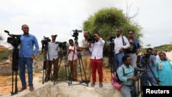 FILE - Somali journalists are seen during a stake-out on the outskirts of Mogadishu, Somalia, July 25, 2019.