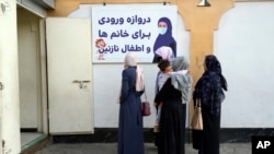 Afghan women stand outside an amusement park, in Kabul, Afghanistan, Nov. 10, 2022.