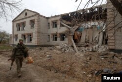 一名乌克兰军人走过赫尔松地区一所被俄军导弹炸毁的幼儿园。（2022年11月9日）
