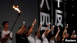 FILE - Activists raise candles in Hong Kong's Victoria Park during a June 4, 2019, vigil to mark the 30th anniversary of the crackdown of China's pro-democracy movement at Beijing's Tiananmen Square.