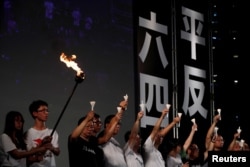 FILE - Pro-democracy activists raise up candles during a candlelight vigil to mark the 30th anniversary of the crackdown of China's pro-democracy movement at Beijing's Tiananmen Square in 1989, at Victoria Park in Hong Kong, June 4, 2019.