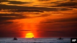 FILE - Lobster fishermen work at sunrise in the Atlantic Ocean, Sept. 8, 2022, off of Kennebunkport, Maine. Scientists, lawyers and government officials are debating deep sea mining at a conference this week. (AP Photo/Robert F. Bukaty, File)