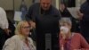 A neutral worker and a Republican and Democratic representative adjudicate ballots cast in the US midterm elections at the Maricopa County Tabulation and Election Center in Phoenix, Arizona, Nov. 9, 2022.