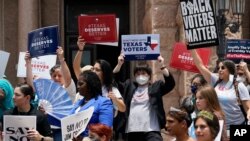 Para demonstran memprotes rancangan undang-undang tentang pemungutan suara di luar gedung kongres Texas di Austin, Texas, pada 13 Juli 2021. RUU tersebut kini telah disahkan meski mendapat penolakan keras dari Partai Demokrat. (Foto: AP)