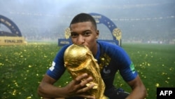 L'attaquant des Bleus, Kylian Mbappé embrasse la Coupe du Monde à Moscou, le 15 juillet 2018 