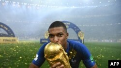 L'attaquant des Bleus Kylian Mbappé embrasse la Coupe du Monde, le 15 juillet 2018 à Moscou