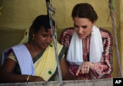 FILE - Britain's Duchess of Cambridge, right, watches an Indian woman make hand woven cloth in Panbari village, east of Gauhati, northeastern Assam state, India, April 13, 2016.