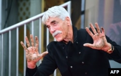 Actor Sam Elliott displays his hands after placing them in the block of cement during his Hand and Footprints ceremony in Hollywood, California, Jan. 7, 2019.