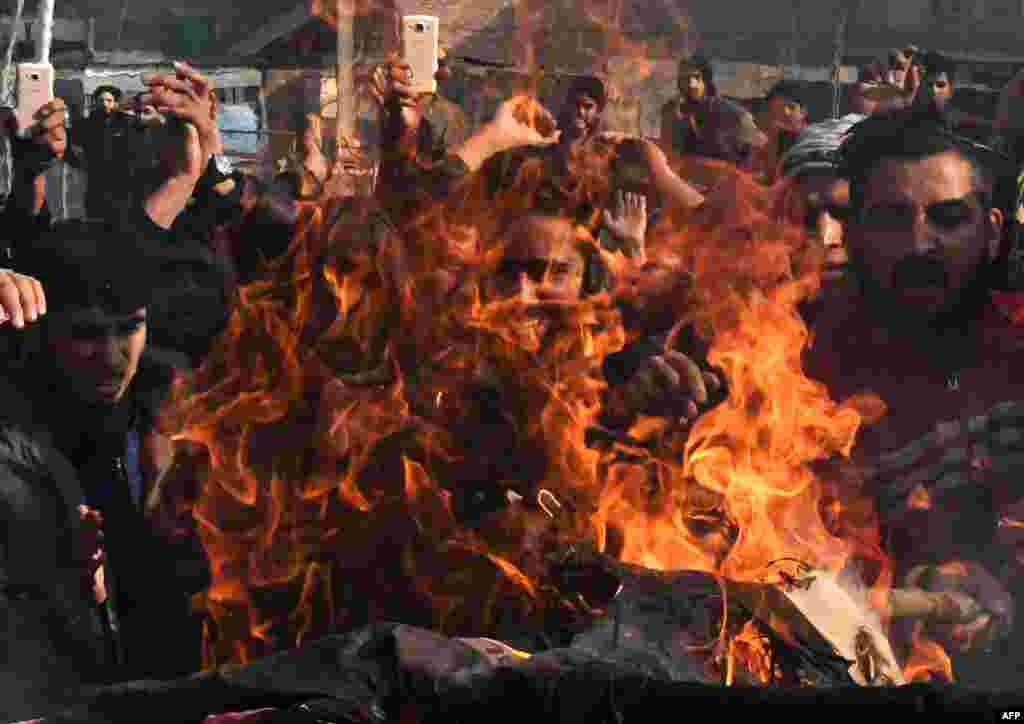 Kashmiri Shitte Muslim shout slogans against the United States and Israel as they burn an effigy of a US President Donald Trumph during a protest in Srinagar following Trump's recognition of Jerusalem as Israel's capital.
