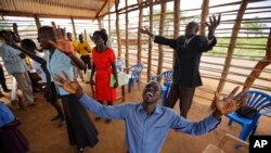 Daniel Rasash, à genou, prient avec un groupe des réfugiés dans une église en paille au camps Bidi Bidi dans le nord de l'Ouganda, 4 juin 2017.