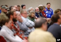 FILE - John Grause, top right, precinct captain for Democratic presidential candidate Hillary Clinton, sits with voters during a Democratic party caucus in Nevada, Iowa, Feb. 1, 2016.