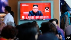 Người dân Hàn quốc xem truyền hình tại nhà ga Seoul, với hình ảnh ông Kim Jong Un và dòng chữ "Triều Tiên nói đã ngưng thử hạt nhân" (ảnh chụp ngày 21/4/2018)