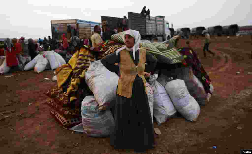 A Syrian Kurdish refugee woman waits for transportation after crossing into Turkey from the Syrian border town Kobani, Oct. 2, 2014.