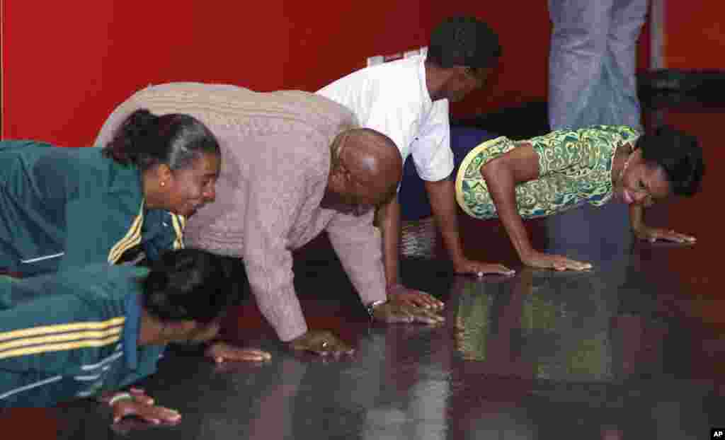 Michelle Obama faz flexões de braços com o arcebispo Desmond Tutu e jovens, durante um evento destinado a promover a saúde e alertar contra a SIDA, na Cidade do Cabo.