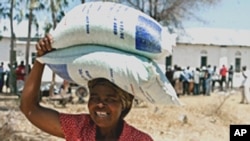 A woman looks happy after receiving bags of food
