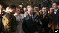 Russian President Vladimir Putin listens to employees of Uralvagonzavod factory in Nizhny Tagil, Russia, March 6, 2018.
