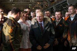 Russian President Vladimir Putin listens to employees of Uralvagonzavod factory in Nizhny Tagil, Russia, March 6, 2018.