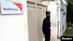 FILE - A security guard stands in front of the World Vision office in Mansehra, north of Islamabad, July 25, 2006. 