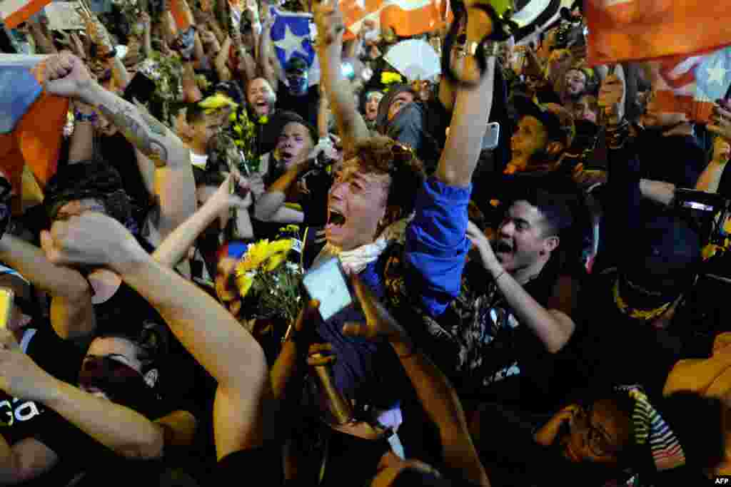 Demonstrators celebrate after the resignation message of the governor of Puerto Rico, Ricardo Rossello in front his mansion known as La Fortaleza in San Juan, on July 24, 2019. 