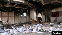 A man walks in a burnt bank during protests over fuel subsidy cuts in Khartoum, Sept. 26, 2013. 