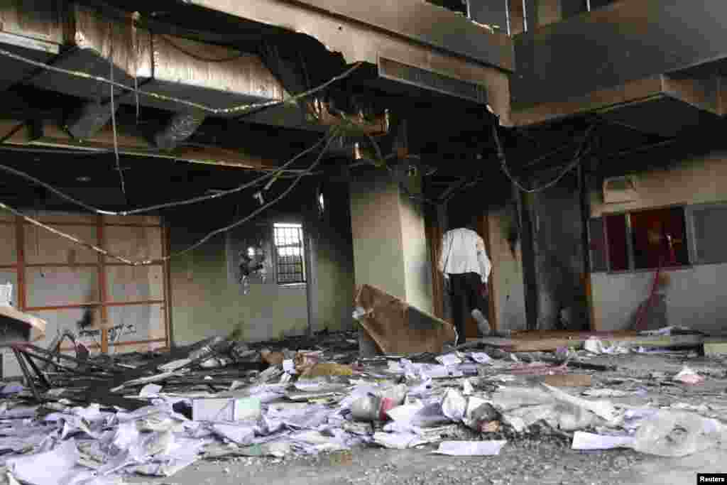 A man walks in a burnt bank during protests over fuel subsidy cuts in Khartoum, Sept. 26, 2013. 