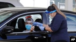 A health care worker takes information from a person at a COVID-19 testing center, in Pleasanton, California, July 21, 2020.