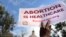 FILE - A supporter of reproductive rights holds a sign outside the Texas State Capitol building during the nationwide Women's March in Austin, Texas, Oct. 2, 2021. 