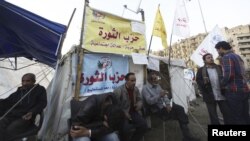 Protesters against Egypt's President Mohamed Morsi rest in front of a tent named "Revolution Party" at Tahrir Square in Cairo, December 17, 2012.