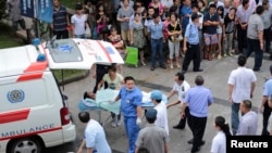 Medical personnel transport a victim (C) to a hospital after an explosion at a factory in Kunshan, Jiangsu province, China, Aug. 2, 2014. 