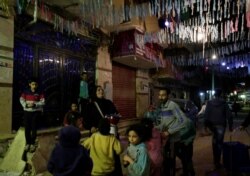 Hajah Dalal Abdelqader, seorang Mesaharati berusia 46 tahun, menabuh genderang untuk membangunkan umat Islam untuk sahur sebelum mereka memulai puasa Ramadhan, di Maadi di Kairo, Mesir, 13 April 2021 (Foto: REUTERS/Hayam Adel)