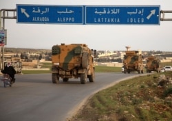 Turkish military vehicles drive in a convoy headed for the south of Idlib province as they pass the town of Atareb in the western countryside of Aleppo province, Feb. 3, 2020.