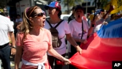 Seorang demonstran dalam protes menuntut digelarnya pemilu, di Caracas, Venezuela (23/1). (AP/Ariana Cubillos)