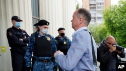 Russian lawyer Ivan Pavlov walks past police officers to attend a court session after speaking to the media at Moscow Court in Moscow, Russia, June 9, 2021. 