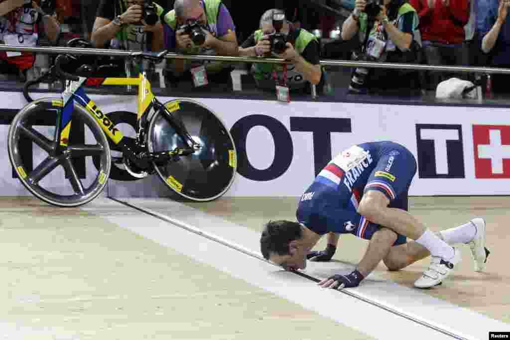 Morgan Kneisky of France kisses the finish line after his victory with teammate Bryan Coquard in the Men&#39;s Madison final at the UCI Track Cycling World Cup in Saint-Quentin-en-Yvelines, near Paris, France.