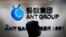 In this Oct. 23, 2020, photo, an employee walks past a logo of the Ant Group at their office in Hong Kong. 