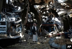 FILE - An elderly man stands among the rubble of the Alsonidar Group's water pump and pipe factory after it was hit by Saudi-led airstrikes in Sana'a, Yemen, Sept. 22, 2016.
