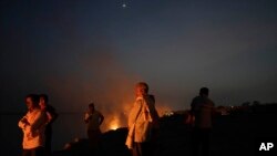 FILE - People cremate their relatives who have died from heat-related illnesses, in Ballia in northern Indian state of Uttar Pradesh, Monday, June 19, 2023.